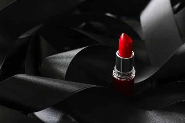 Red lipstick on black silk background, luxury make-up and beauty cosmetic