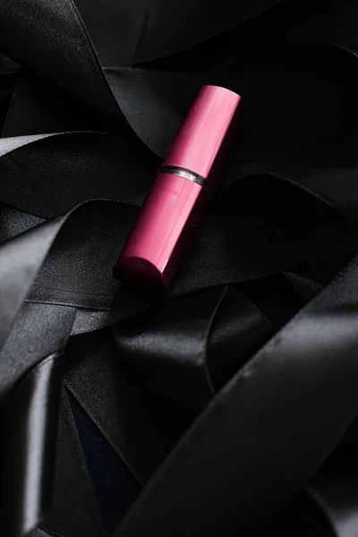 Lápiz labial rosa sobre fondo de seda negro, maquillaje de lujo y cosméticos de belleza — Foto de Stock