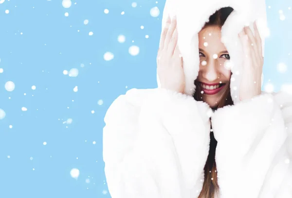 Beyaz kapüşonlu kürk giyen genç bir kadının Noel ve kış tatili portresi, mavi arka planda kar, moda ve yaşam tarzı — Stok fotoğraf