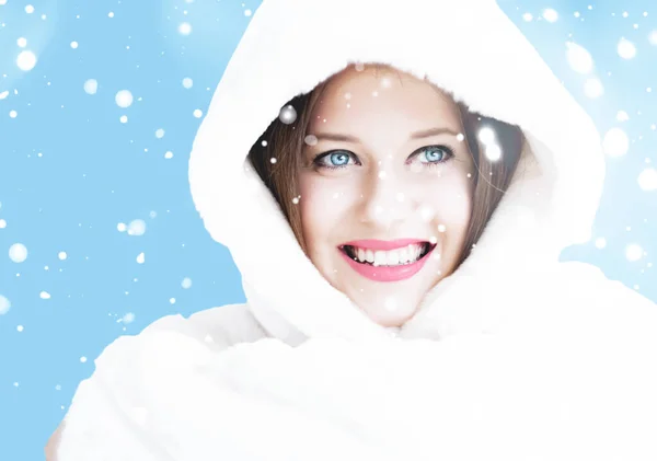 Рождественский и зимний праздничный портрет молодой женщины в белой шубе в капюшоне, снег на синем фоне, мода и стиль жизни — стоковое фото