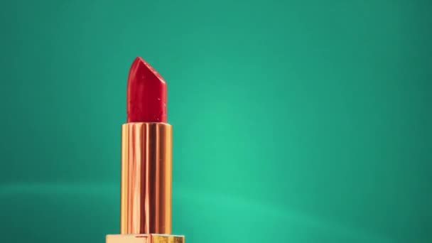 Chique rode lippenstift in gouden buis op groene achtergrond en stralende lichtfakkels, luxe make-up product en vakantie cosmetica voor beauty merk — Stockvideo