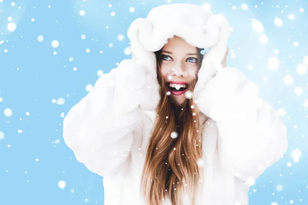 Kerst en winter vakantie portret van jonge vrouw in witte capuchon bontjas, sneeuw op blauwe achtergrond, mode en levensstijl — Stockfoto