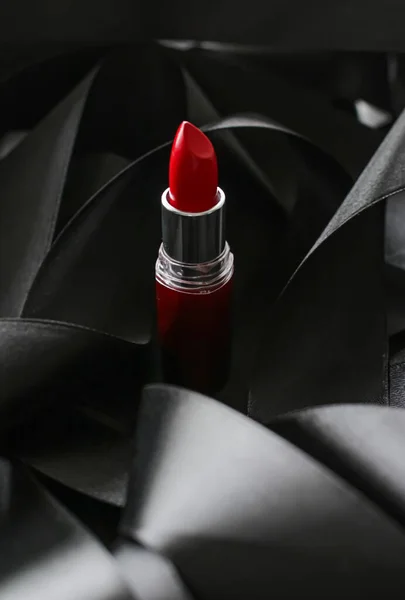 Lápiz labial rojo sobre fondo de seda negro, maquillaje de lujo y cosméticos de belleza — Foto de Stock
