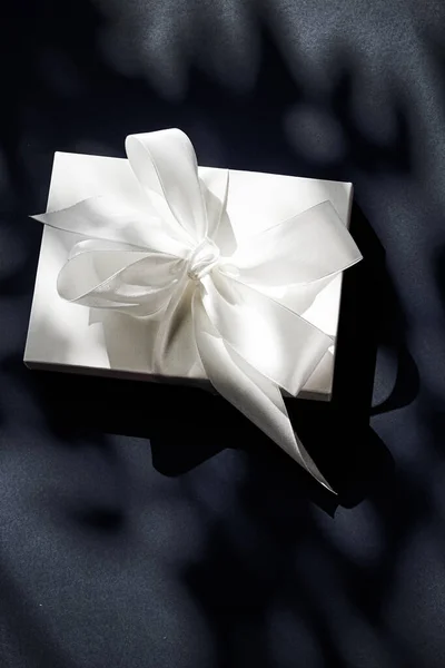 Caixa de presente branca de férias de luxo com fita de seda e arco sobre fundo preto, casamento de luxo ou presente de aniversário — Fotografia de Stock