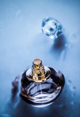 Mavi suyun altında parfüm şişesi, büyüleyici bir koku gibi taze deniz kıyısı kokusu ve bayram hediyesi olarak eau de parfum ürünü, lüks güzellik spa markası.