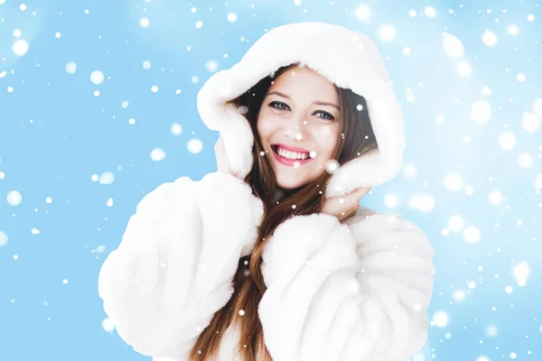 Natale e vacanza invernale ritratto di giovane donna in pelliccia bianca con cappuccio, neve su sfondo blu, moda e stile di vita — Foto Stock