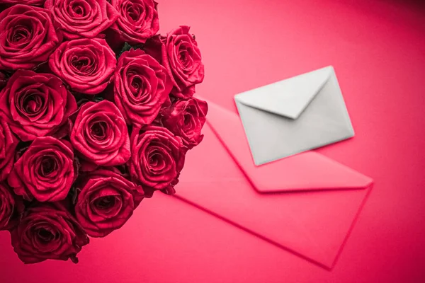 Sevgililer Günü 'nde aşk mektubu ve çiçek teslimatı. Lüks bir buket gül ve pembe arka planda romantik tatil tasarımı için kart. — Stok fotoğraf