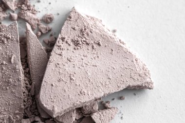 Makyaj paleti gibi soluk göz farı pudrası beyaz arka planda izole edilmiş, ezilmiş kozmetik ve güzellik dokusu