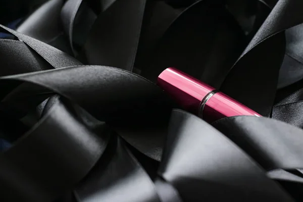 Lápiz labial rosa sobre fondo de seda negro, maquillaje de lujo y cosméticos de belleza — Foto de Stock