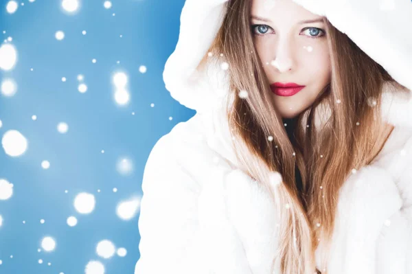 Feliz Natal e férias de inverno retrato de jovem mulher de casaco de pele com capuz branco, neve no fundo azul, moda e estilo de vida — Fotografia de Stock