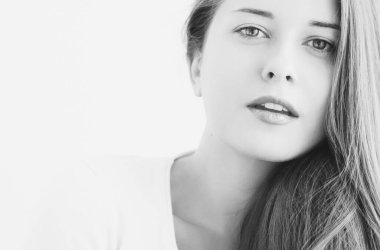 Genç bir kadının güzel yüzü, doğal makyaj görünüşü, cilt bakımı ve saç bakımı.