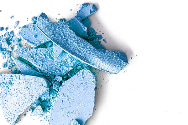 Makyaj paleti olarak mavi far pudrası beyaz arka planda izole edilmiş, ezilmiş kozmetik ve güzellik dokusu