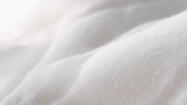 Beyaz tüylü kürk deseni, sıcak kış giysileri, lüks tekstil ve kumaş arka plan sallanıyor ve hareket ediyor.