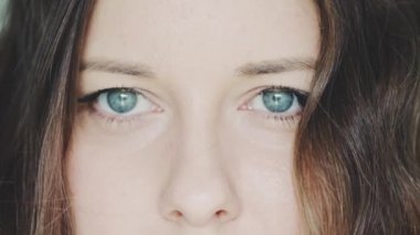 Mavi gözler yakın çekim, genç bir kadının bakışları, sağlık ve vizyon konsepti.
