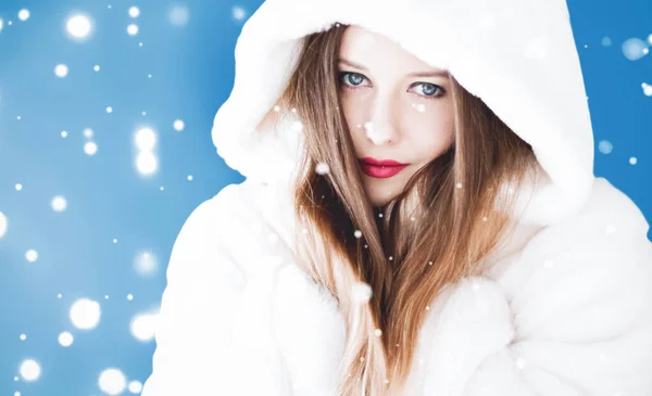 С Рождеством и зимним праздником портрет молодой женщины в белой шубе в капюшоне, снег на синем фоне, мода и образ жизни — стоковое фото