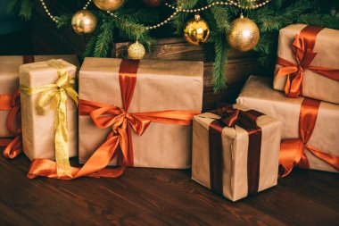 Hediye kutuları ve altın Noel ağacı, tatil evi dekorasyonu olarak köy tarzı hediyeler ve dekorlar.