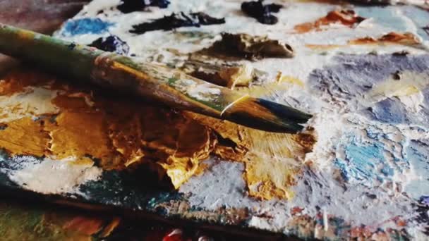 Sanatçı stüdyosunda sanat aletleri, boya fırçaları ve yağ paleti, yaratıcı hobi ve sanatsal çalışma alanı — Stok video