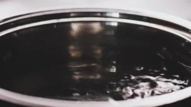 Mutfak ocağında kaynar su, tavadan yükselen sıcak buhar, evde kalıp yemek pişirme, online aşçılık ve yemek hazırlama.