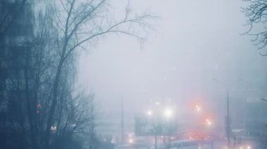 Kasvetli şehir sokak manzarası sisli kış gününde trafik, karanlık, sinematik film efekti ve iş arka planı, ulaşım ve şehir hayatı sahnesinde ağaçlar ve araba ışıkları