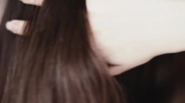 Esmer, uzun saçlı bir kadın. Parlak saçlarını, doğal saç bakımını, stilini, güzelliğini ve sağlığını tarıyor.