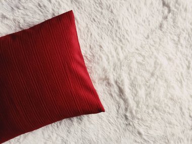 Kırmızı yastık beyaz pofuduk ekose battaniyeye, düz arkaplan, yatak odası üst görünümü ve ev dekorasyonu olarak yastık fırlat