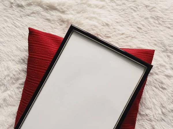 写真プリントモックアップ 赤いクッション枕とふわふわの白い毛布 フラットレイ背景とアート製品 トップビューとして空白のコピースペースと黒の薄い木製フレーム — ストック写真