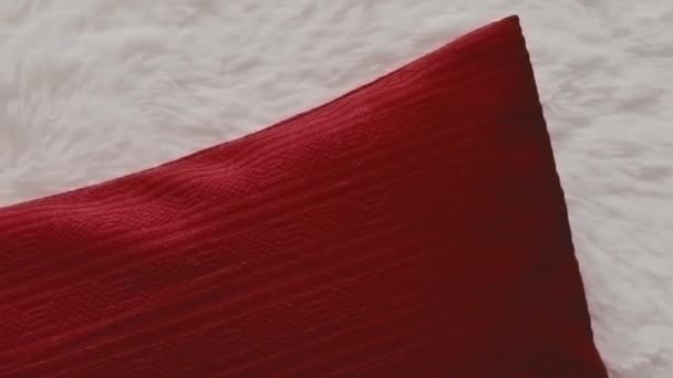 白いふわふわのベッドカバーに赤い枕を投げる 家の装飾 — ストック動画