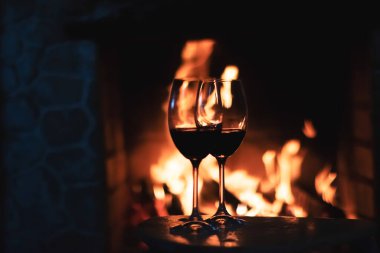 Şöminenin önünde kırmızı şarap, evde rahatlatıcı bir atmosfer.