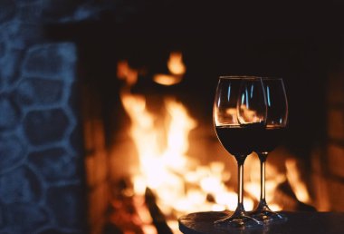 Şöminenin önünde kırmızı şarap, evde rahatlatıcı bir atmosfer.