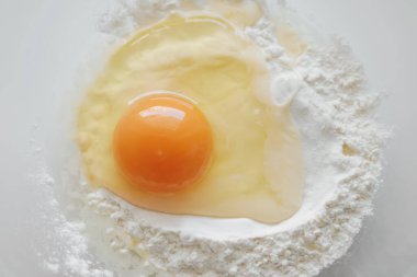 Çiğ yumurta ve un, hamuru pişirme işlemi için hazırlıyorum.