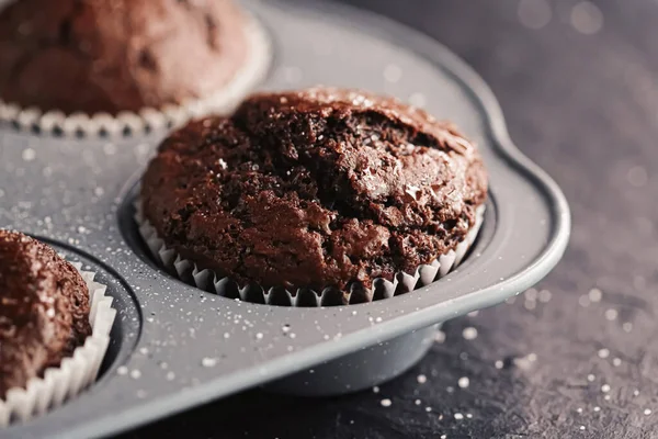 Just baked chocolate muffins in tray, homemade comfort food recipe concept