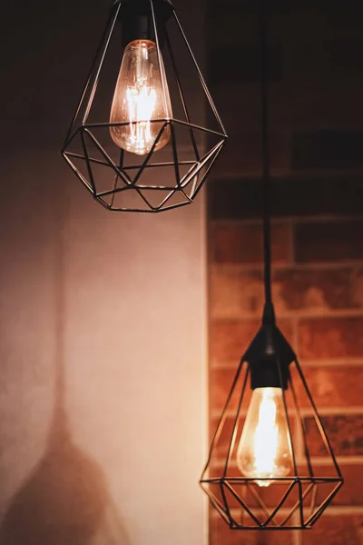 Pendant industrial lamps in loft interior with dark brick walls, modern design and home decor