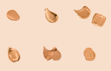 Bej arka plan, güzellik ve kozmetik üzerinde izole makyaj dokusu olarak sıvı temel lekeleri, lekeler, lekeler ve felçler