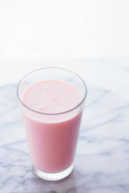 Tatlı içecek, yemek servisi ve yemek servisi olarak mermer arka planda çilekli süt.