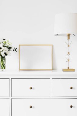 Beyaz mobilyalar, lüks ev dekorasyonu ve maket tasarımı üzerine altın yatay çerçeve ve taze çiçek demeti