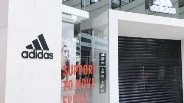 Bezárt Adidas márkabolt egy bevásárlóközpontban a Coronavirus covid-19 világjárvány lezárása alatt, üzletkorlátozás — Stock videók