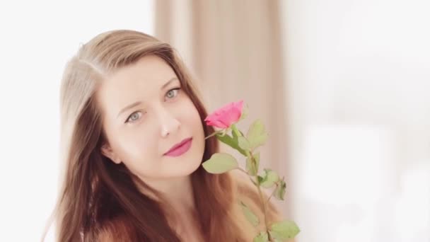 Attraktive junge Frau mit einem schönen rosa Garten Rosenblüte, natürliche Schönheit Gesicht Porträt eines kaukasischen europäischen Modell als Wellness, Hautpflege und Menschen — Stockvideo