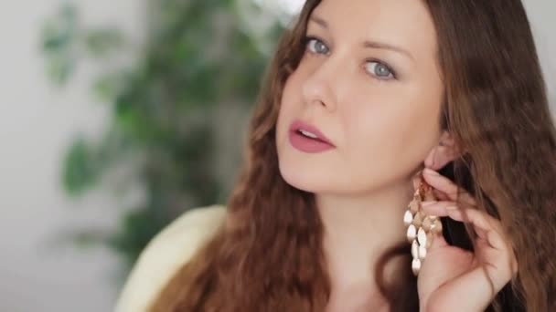 Gyönyörű nő visel hosszú arany fülbevaló és mosolygós, kaukázusi európai női modell pózol arany ékszerek és elegáns kiegészítők, divat és ékszerek kereskedelmi — Stock videók