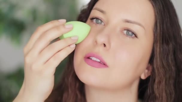 Hermosa mujer que aplica maquillaje orgánico natural usando licuadora de belleza y sonriente, herramienta de esponja de maquillaje ecológico, retrato facial de modelo caucásico o vlogger como producto cosmético, cuidado de la piel y concepto de personas — Vídeos de Stock