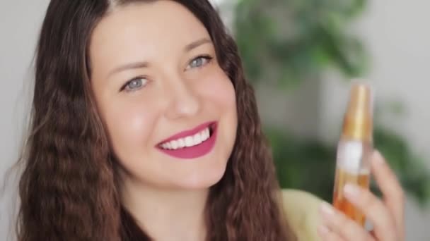 Hermosa mujer joven sonriente sosteniendo producto cosmético, eco cosméticos orgánicos aerosol como belleza natural y cuidado de la piel y el cabello diario saludable rutina, personas y bienestar comercial — Vídeos de Stock