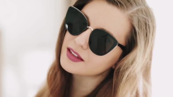 Vacker affärskvinna bär snygga solglasögon och leende, skönhet ansikte porträtt av en kaukasisk europeisk modell som mode, tillbehör och affärsmän koncept — Stockvideo