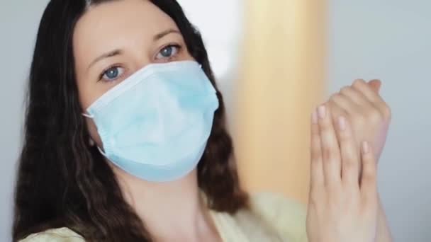 Жінка в захисній масці для обличчя миє руки з дезінфікуючим милом, крем для рук або антивірусний, антибактеріальний гель як гігієна при пандемії коронавірусу, профілактиці вірусної інфекції та захисті здоров'я — стокове відео