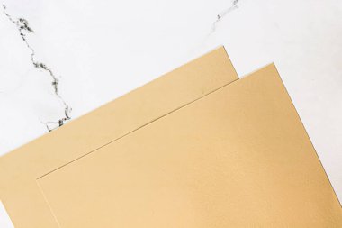 Beyaz mermer arka plan üzerine bej renkli A4 kağıtları ofis kırtasiyesi düz yatak, lüks markalaşma yatağı ve model kimlik tasarımı