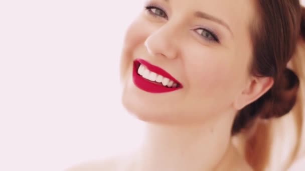 รูปภาพใบหน้าที่สวยงามของหญิงสาวที่ยิ้มยิ้ม ยิ้มฟันขาวที่สมบูรณ์แบบ แต่งหน้าสวยงามด้วยเครื่องสําอางธรรมชาติ นางแบบผิวขาวที่สวยงาม โพสสําหรับการดูแลผิวและแต่งหน้า — วีดีโอสต็อก