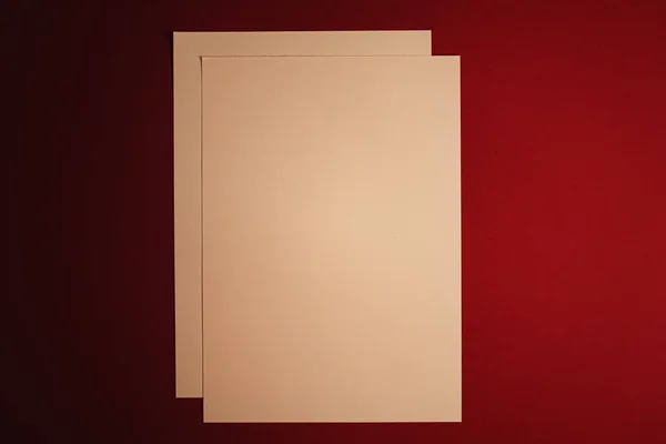 Papel A4 en blanco, beige sobre fondo rojo oscuro como plano de papelería de oficina, diseño de identidad de marca e identidad de marca de lujo para maqueta — Foto de Stock