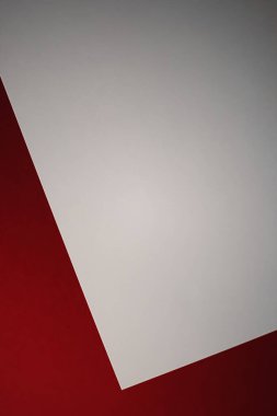 Boş A4 kağıt, kırmızı zemin üzerine beyaz ofis kırtasiyesi düz kaplama, lüks markalaştırma yatağı ve model kimlik tasarımı