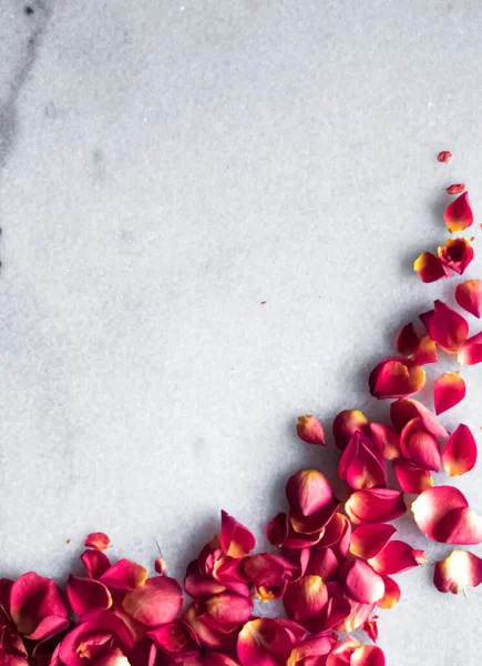 Лепестки роз на мраморном фоне, цветочный декор и свадебный уголок, праздничная открытка на заднем плане для приглашения на мероприятие, плоский дизайн — стоковое фото