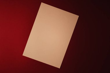 Boş A4 kâğıdı, koyu kırmızı arka planda bej ofis kırtasiyesi, lüks markalaşma düz yatak ve model kimlik tasarımı