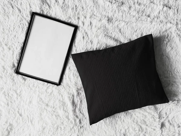 Dünner Holzrahmen mit leerem Kopierraum als Poster-Fotoprint-Attrappe, schwarzes Kissenkissen und flauschige weiße Decke, flacher Hintergrund und Kunstprodukt — Stockfoto