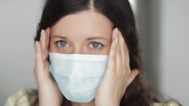 얼굴을 보호하는 마스크를 쓴 겁에 질린 여성은 공포, 스트레스, 불안, 부정적 인 감정, 코로나 바이러스 대유행, 바이러스 감염 예방 및 건강 관리로 인한 격리 조치를 경험 한다. — 비디오